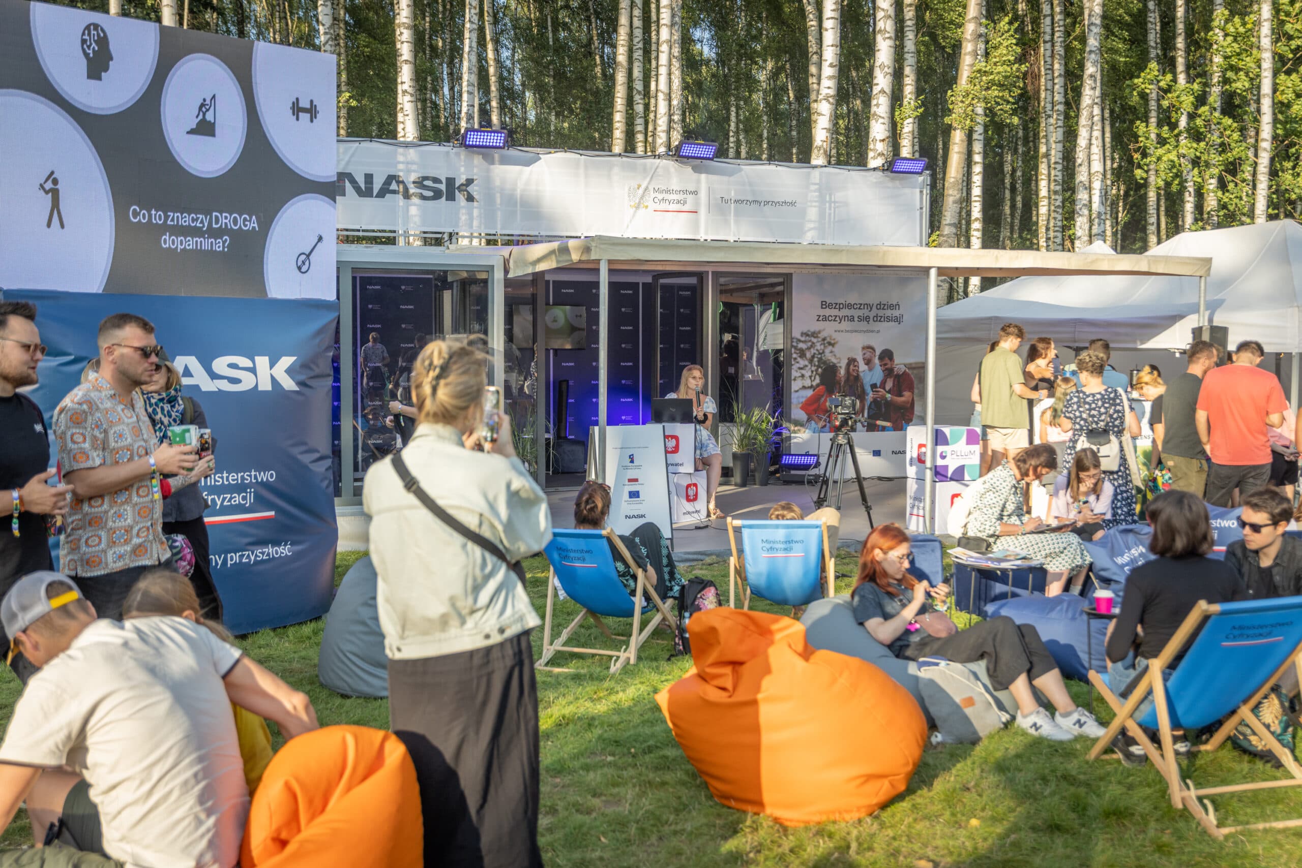 Stoisko NASK na festiwalu z uczestnikami. 
