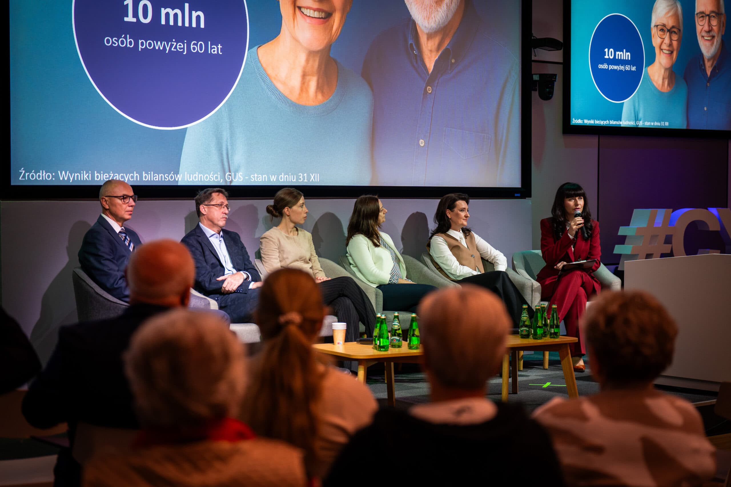 Paneliści podczas debaty na Kongresie Gospodarki Senioralnej siedzą na scenie przed publicznością. Na ekranie za nimi widoczny jest slajd informujący, że w Polsce żyje 10 milionów osób powyżej 60. roku życia.