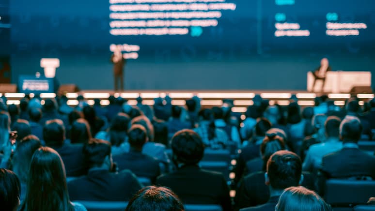 Publiczność słuchająca prelekcji na ogromnej scenie